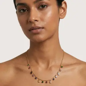 Model wearing gold plated multicolor gemstone charm necklace